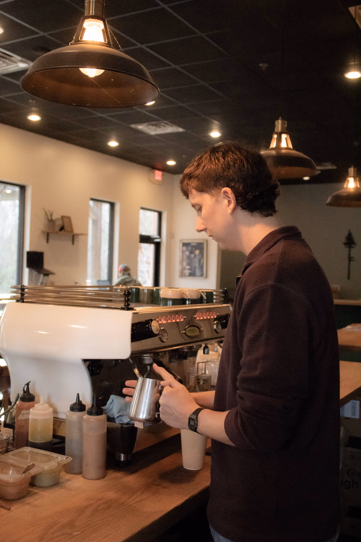 Barista steaming milk on the espresso machine at Old Pine Coffee Roasters